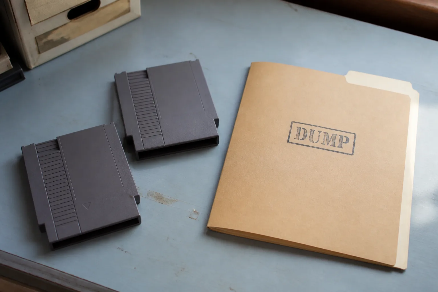 Game cartridge lying next to an open laptop showing a file listing and a card reader